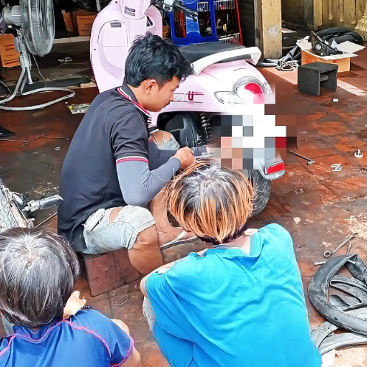 将来の自立を目指し、職業訓練として自転車の修理技術を学ぶラオスの少年。未来への投資としての支援活動。