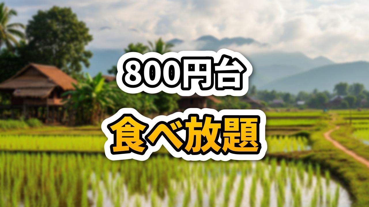 ラオスのITECCモールにあるPrince's Steakで、熱々の鉄板に乗ったTボーンステーキにソースをかけている様子。背景には食べ放題のエビやサラダが見える。